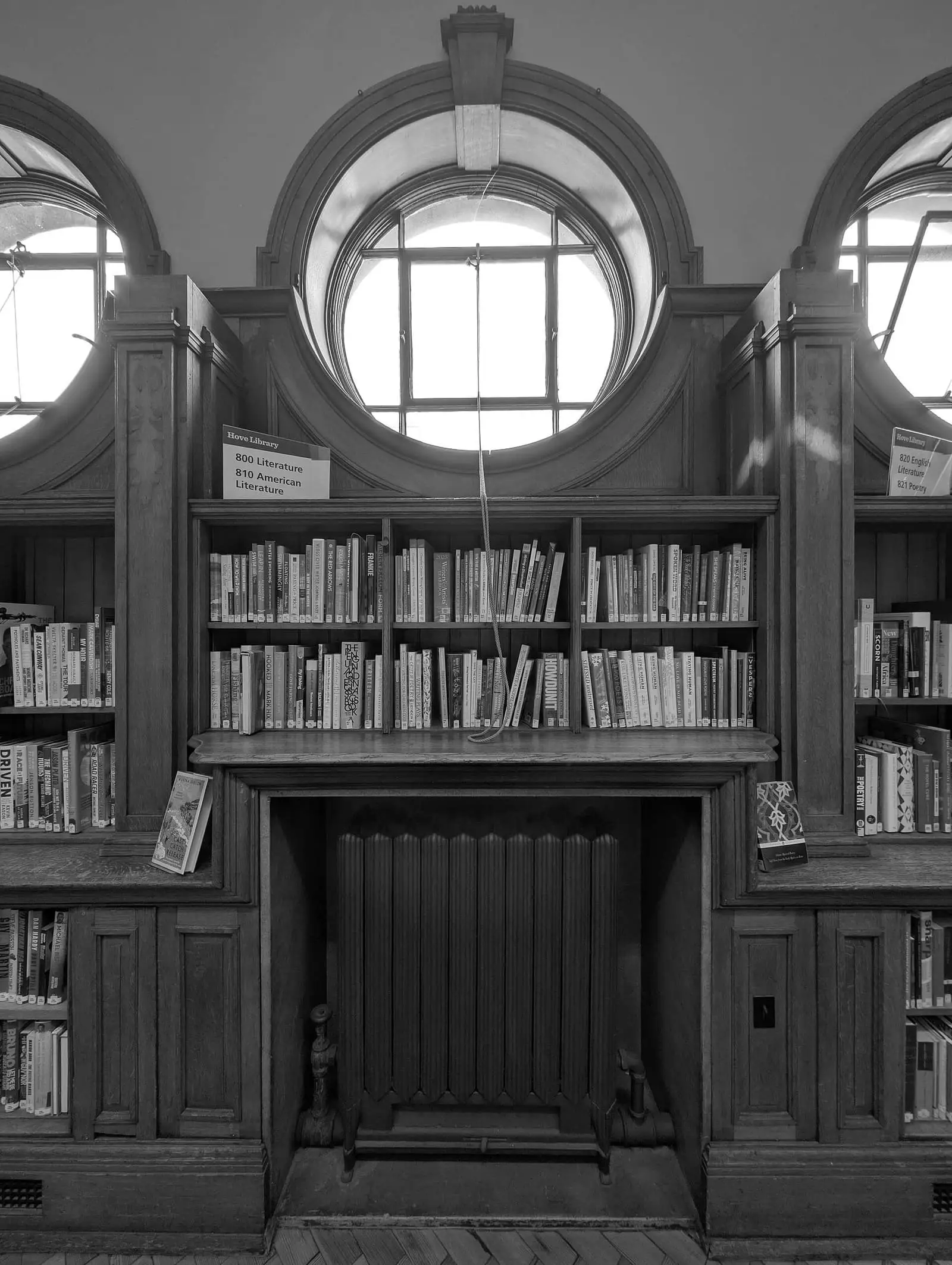 Tall bookshelves in a public library, in black and white.
